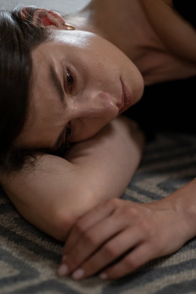 Close-up of a woman lying down, expressing sadness and crying.
